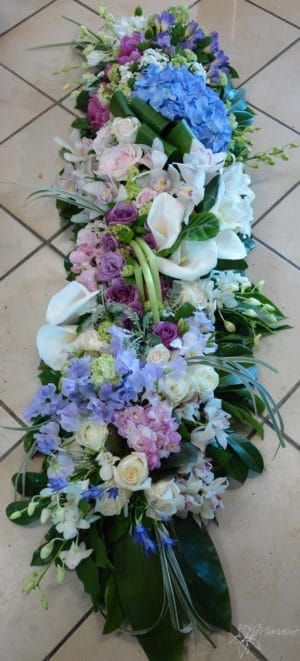 raquette de deuil avec fleurs blanches, bleues et violettes