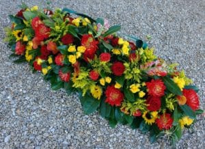 raquette de deuil avec fleurs rouges et jaunes