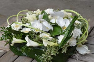 coussin carré de deuil avec diverses fleurs blanches