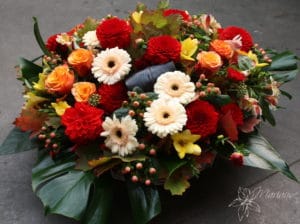 coussin rond de deuil avec roses rouges, oranges et fleurs blanches