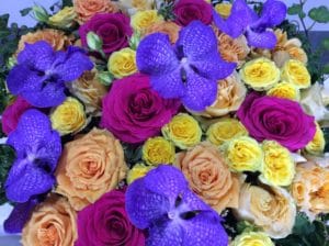 zoom sur le coussin rond de deuil avec roses pastel et fleurs violettes
