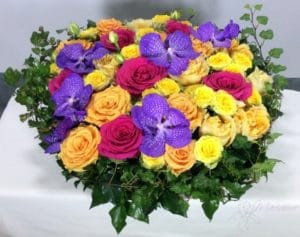 coussin rond de deuil avec roses pastel et fleurs violettes