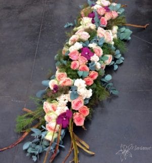 raquette de deuil avec fleurs blanches, roses et violettes
